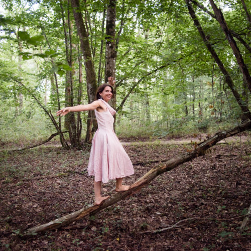 Femme en équilibre sur une branche dans la forêt
