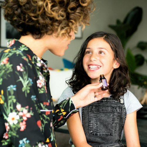 Une mère fait sentir un flacon d'huile essentielle à sa fille